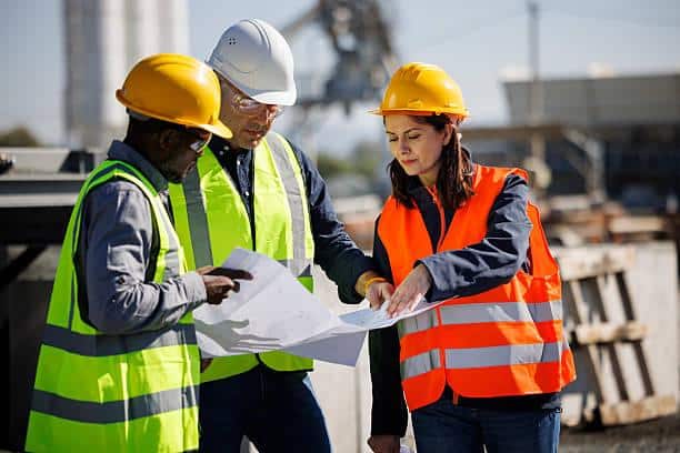 Structural engineer reviewing building construction drawings on site in Nigeria